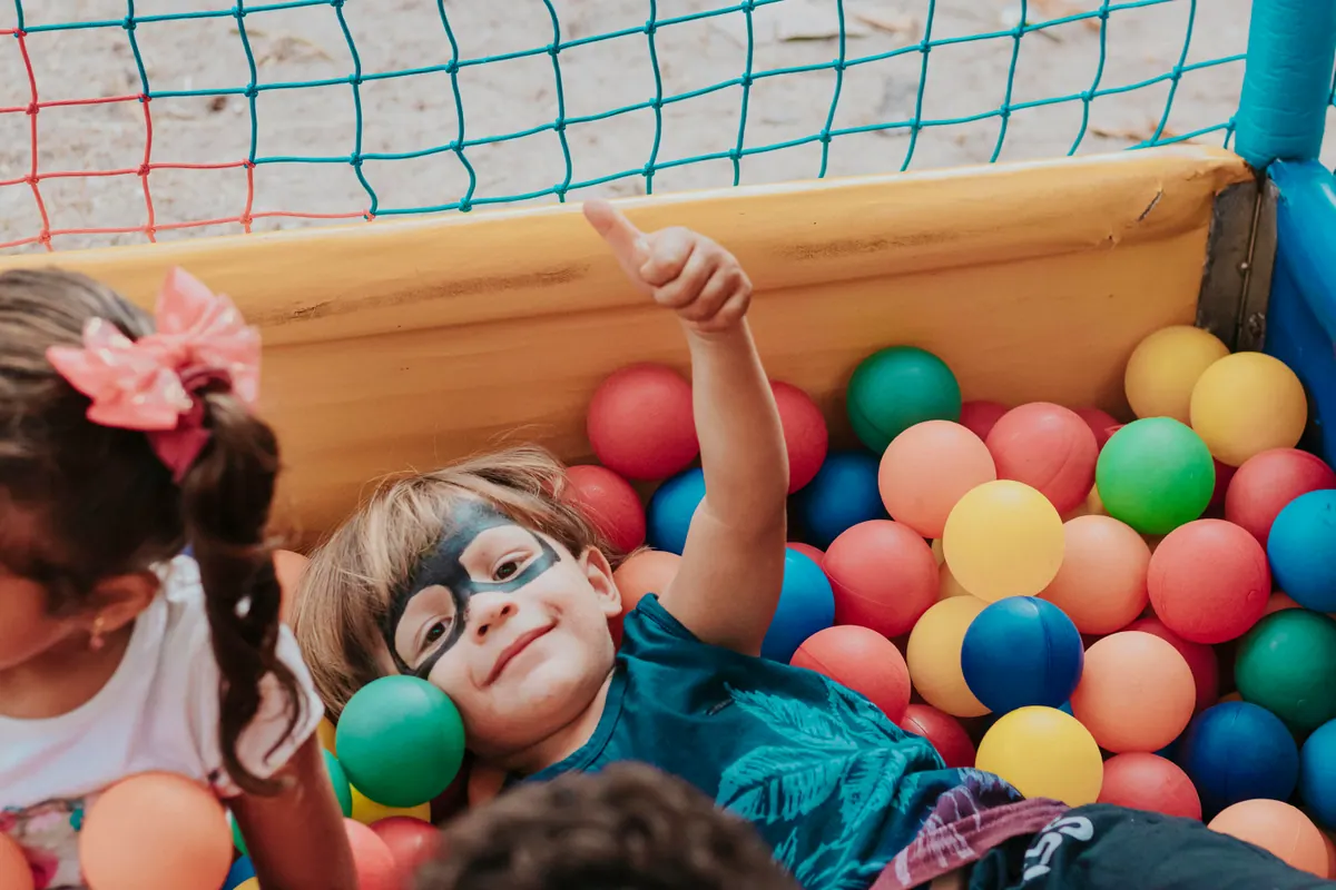 A child playing in a ball pit at a community playground