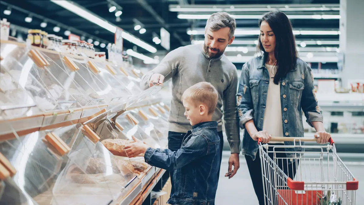 A family shopping together in a real grocery store, practicing everyday community skills