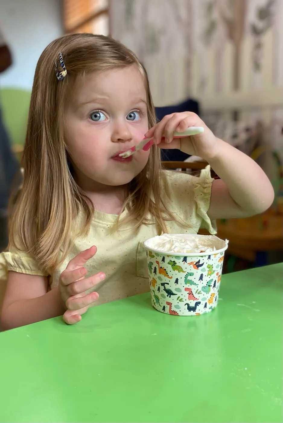 A young girl enjoying a snack at a table during a Traina session