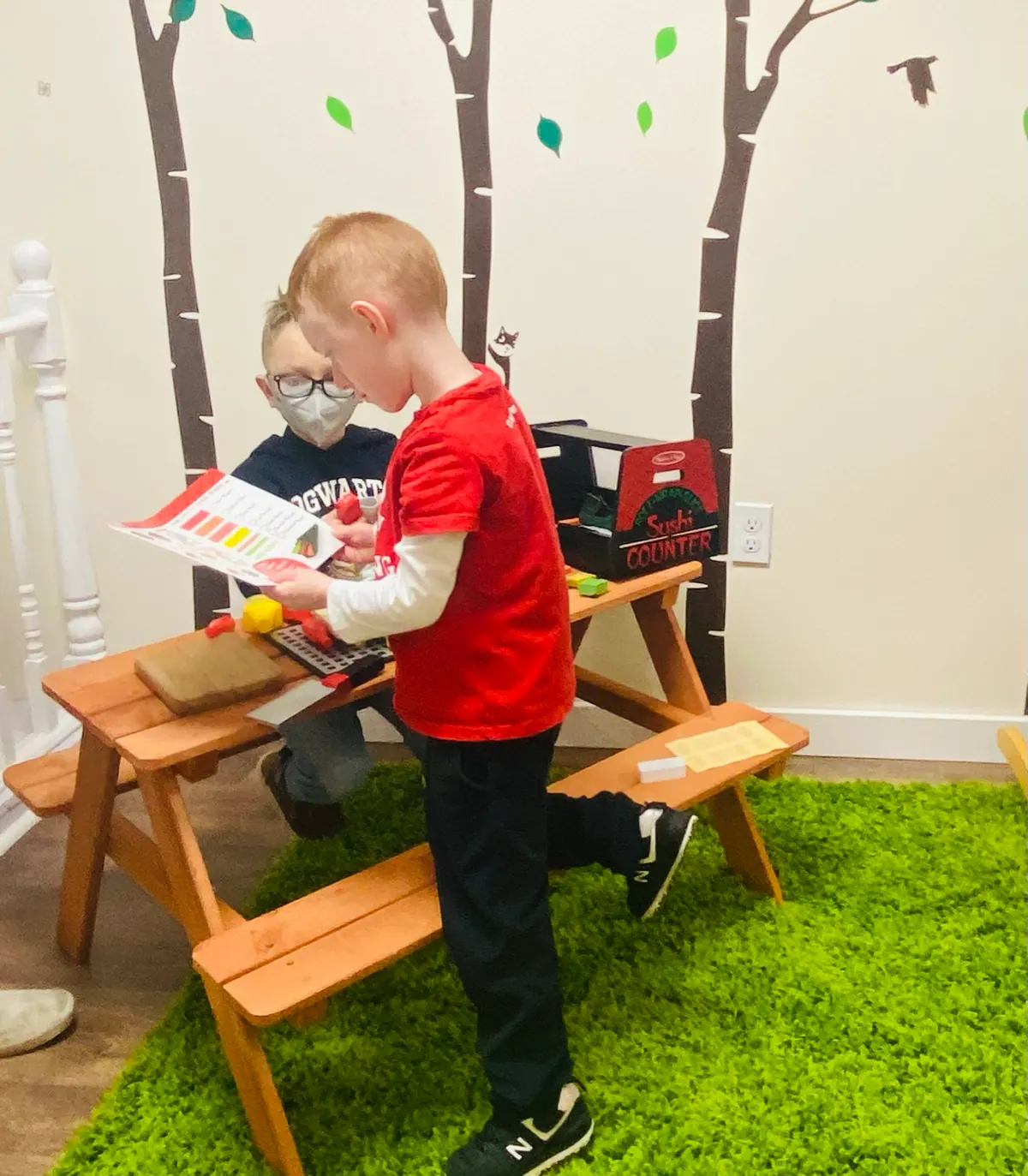 Two children working on a reading activity together at a small table
